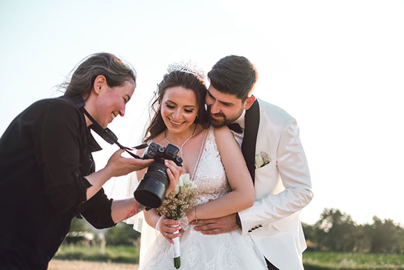 Photographe professionnelle lors d'un mariage montrant aux mariés le résultats de leur photo de mariés