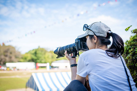 Photographe professionnelle réalisant un reportage photo lors d'un séminaire d'entreprise en plein air